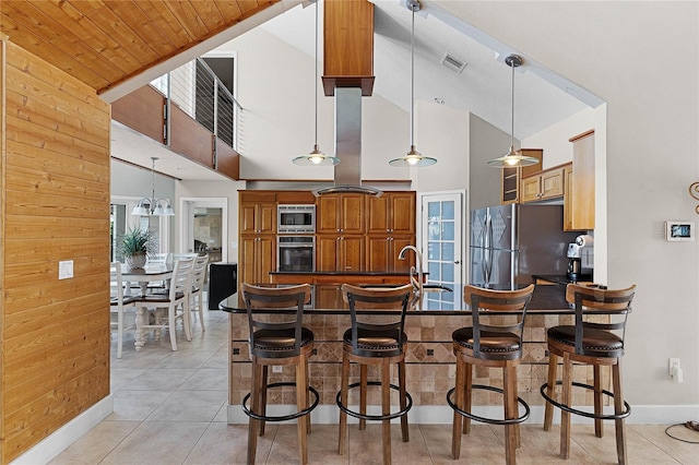 kitchen with a breakfast bar area, appliances with stainless steel finishes, high vaulted ceiling, and a healthy amount of sunlight