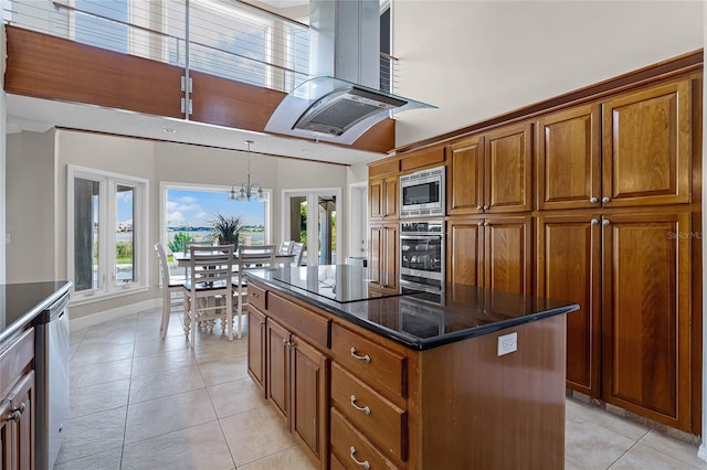 kitchen featuring light tile patterned floors, a kitchen island, decorative light fixtures, extractor fan, and stainless steel appliances