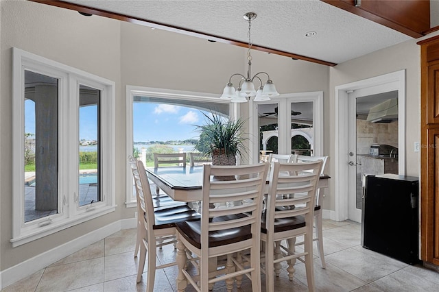 8605 Bay Shore Cv, Orlando, FL 32836 - dining area with light tile patterned floors, a notable chandelier, a textured ceiling, and baseboards