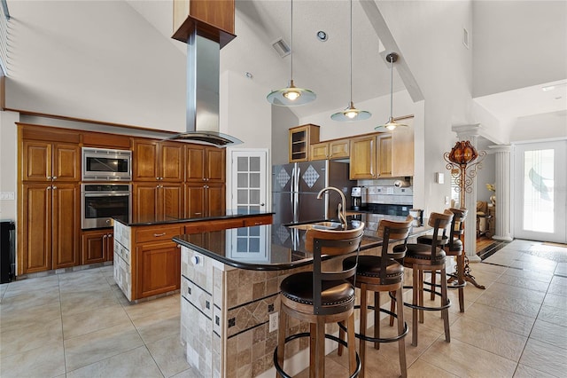 kitchen featuring high vaulted ceiling, a center island with sink, and appliances with stainless steel finishes