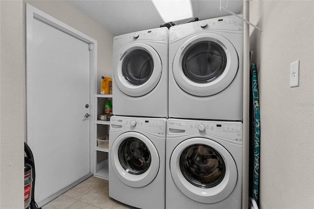 laundry area with light tile patterned floors, stacked washer / drying machine, and independent washer and dryer