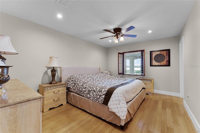 bedroom with light hardwood / wood-style flooring, ceiling fan, and a textured ceiling