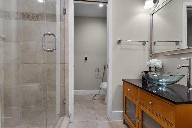 bathroom with tile patterned flooring, vanity, toilet, and an enclosed shower