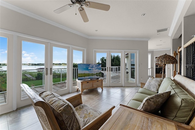 tiled living room with french doors, crown molding, ceiling fan, and a healthy amount of sunlight