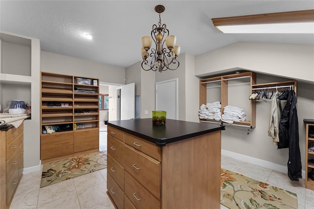 walk in closet with a chandelier, vaulted ceiling, and light tile patterned flooring