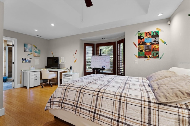 bedroom with ceiling fan, light wood-type flooring, and ensuite bathroom