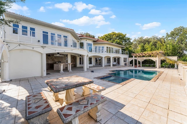 back of house featuring a patio, a balcony, a pool with hot tub, a pergola, and ceiling fan