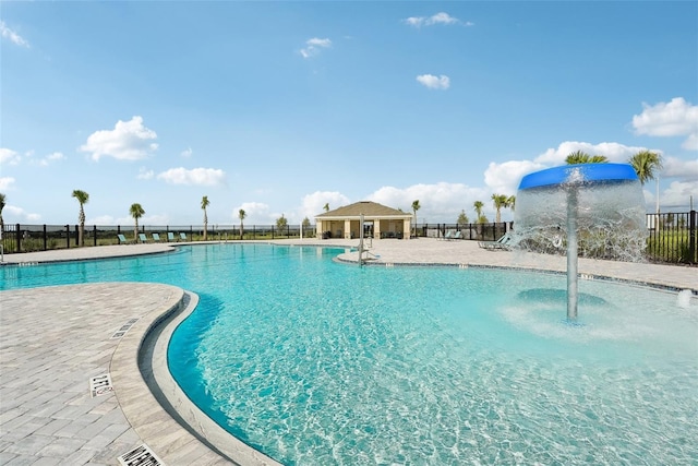 pool with a patio area and fence