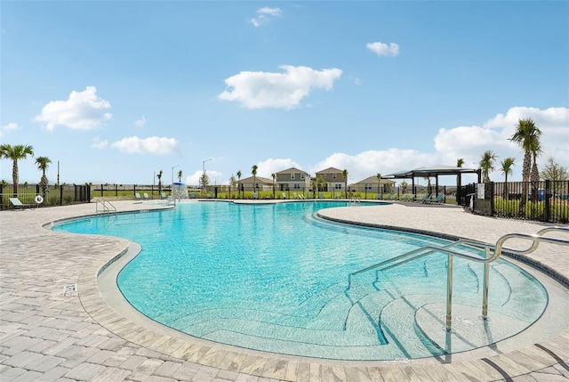 community pool with a patio and fence