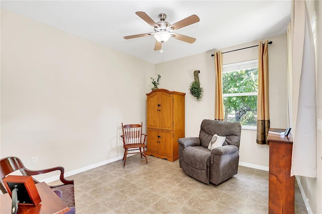 living area featuring light tile patterned floors, baseboards, and ceiling fan