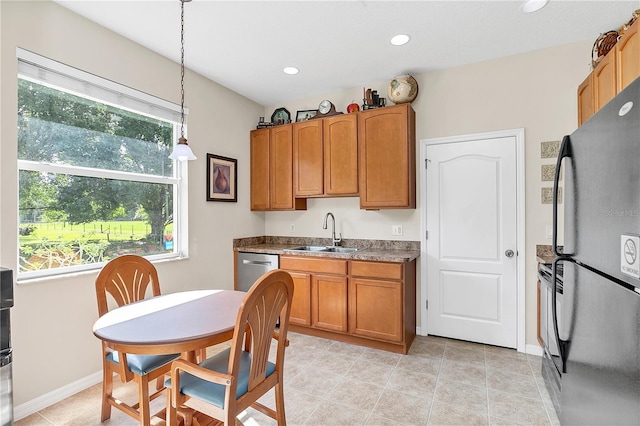 kitchen with pendant lighting, a sink, freestanding refrigerator, recessed lighting, and brown cabinetry