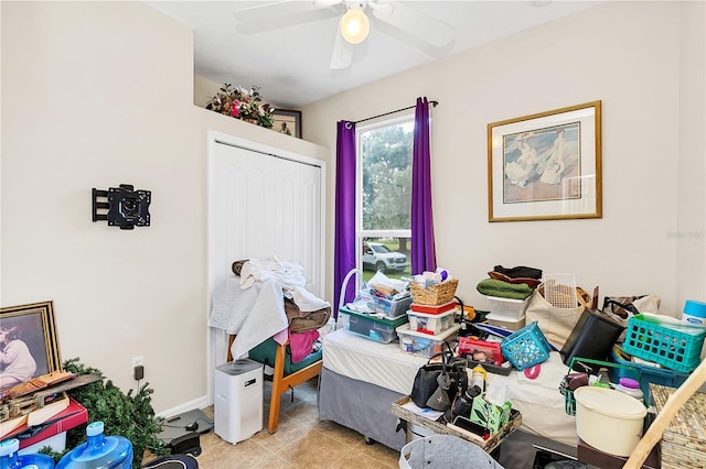 bedroom with a closet, light tile patterned floors, baseboards, and a ceiling fan