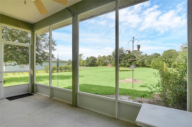 unfurnished sunroom featuring ceiling fan