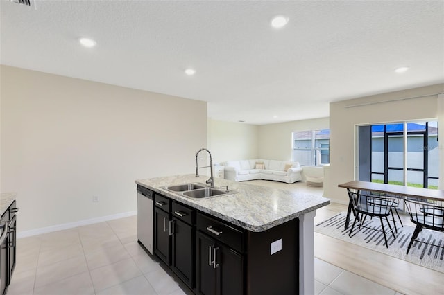 kitchen featuring a textured ceiling, light hardwood / wood-style flooring, sink, a kitchen island with sink, and stainless steel dishwasher