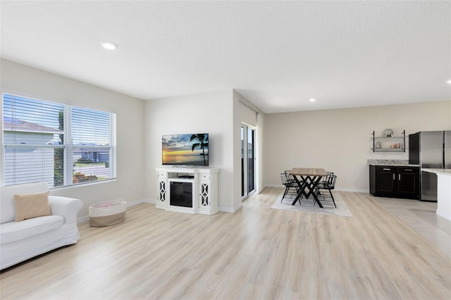 living room featuring a textured ceiling and light hardwood / wood-style floors