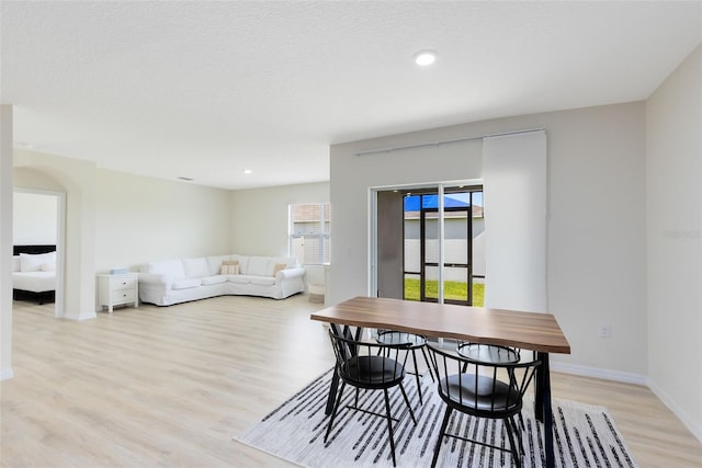 dining space featuring a textured ceiling and light hardwood / wood-style floors