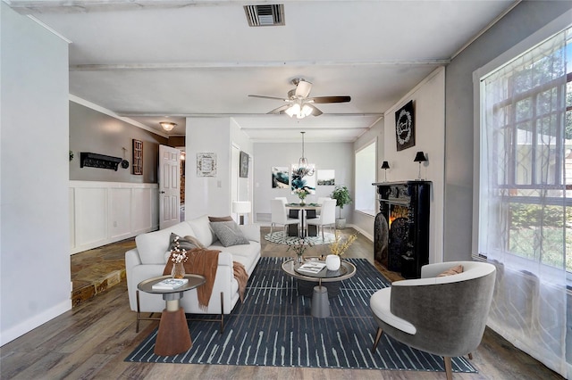 living room featuring wood-type flooring, ornamental molding, and ceiling fan