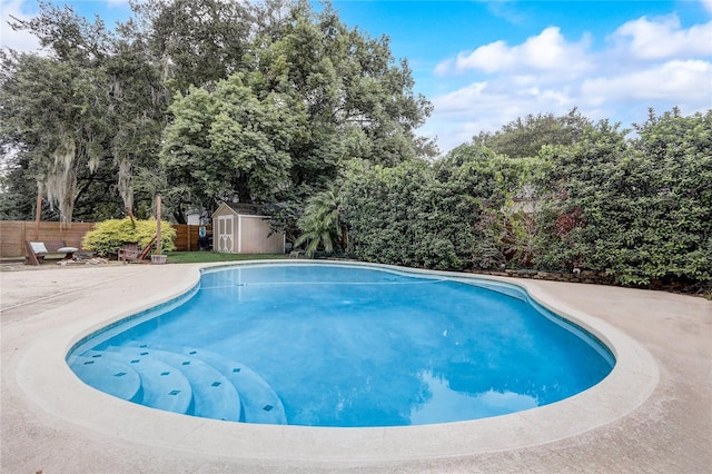 view of pool with a patio and a storage shed