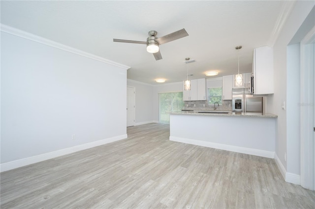 kitchen featuring crown molding, stainless steel refrigerator with ice dispenser, backsplash, light wood-style floors, and white cabinetry