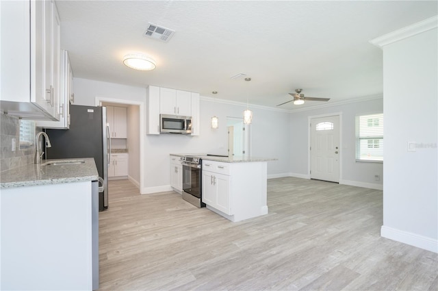 kitchen featuring stainless steel appliances, a peninsula, visible vents, white cabinets, and ornamental molding