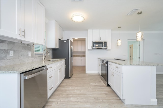 kitchen with stainless steel appliances, backsplash, light wood-style flooring, white cabinetry, and a sink