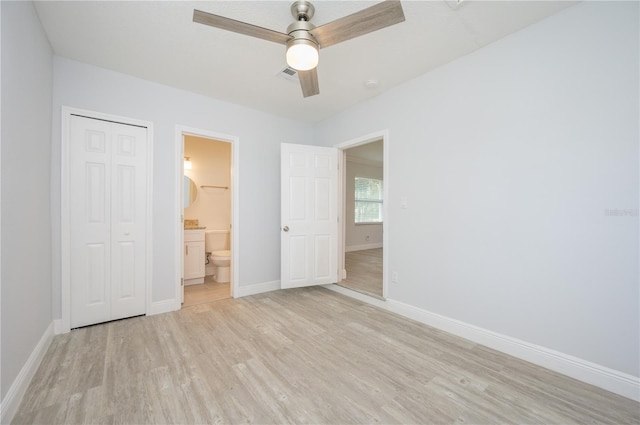 unfurnished bedroom with light wood finished floors, baseboards, a closet, and ensuite bathroom