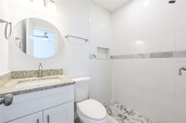 bathroom featuring tiled shower, vanity, and toilet