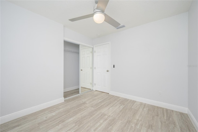 unfurnished bedroom with light wood-style flooring, a ceiling fan, visible vents, and baseboards