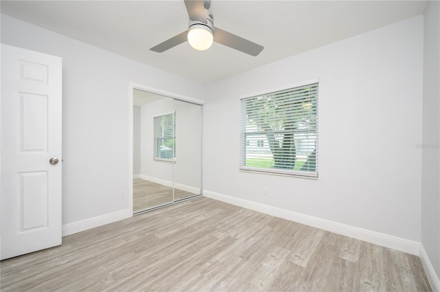 unfurnished bedroom with a closet, wood finished floors, a ceiling fan, and baseboards