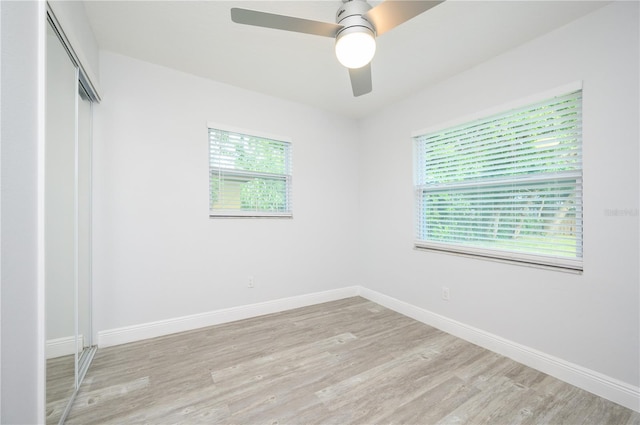 unfurnished bedroom featuring baseboards, multiple windows, and light wood-style floors