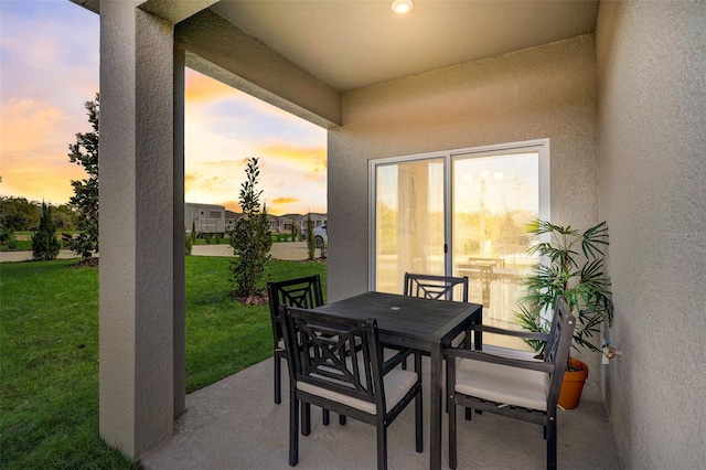 patio terrace at dusk featuring a yard