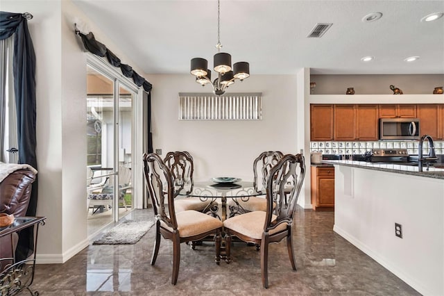 dining area with sink and a chandelier