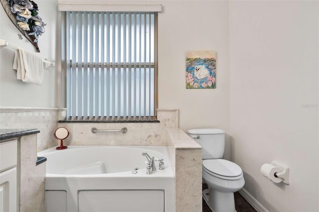 bathroom featuring a bath, vanity, and toilet