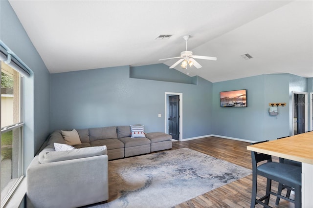 living room with hardwood / wood-style flooring, ceiling fan, and lofted ceiling