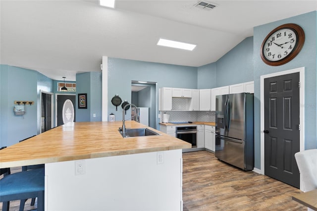 kitchen with backsplash, sink, a breakfast bar area, white cabinetry, and stainless steel appliances