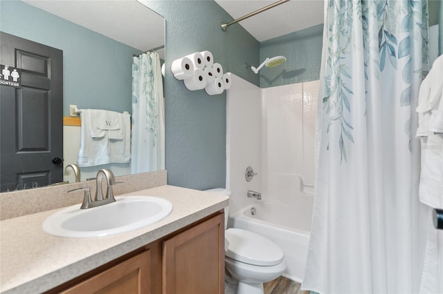 full bathroom featuring vanity, toilet, shower / bath combo with shower curtain, and a textured ceiling