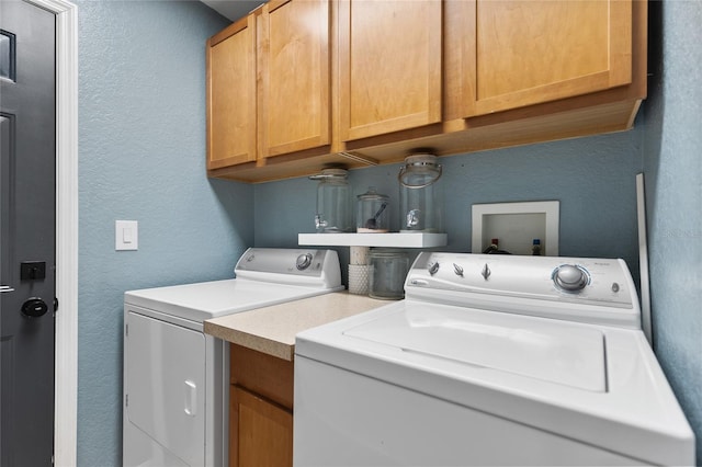 washroom with washer and dryer and cabinets