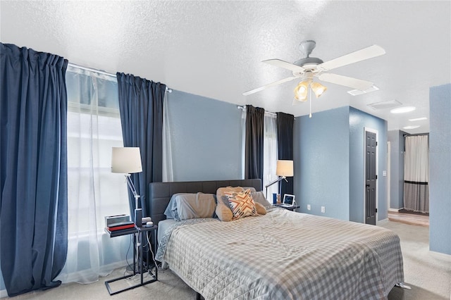 carpeted bedroom with ceiling fan and a textured ceiling