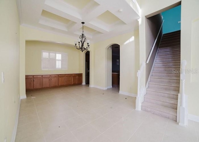 spare room featuring crown molding, coffered ceiling, beam ceiling, and a notable chandelier