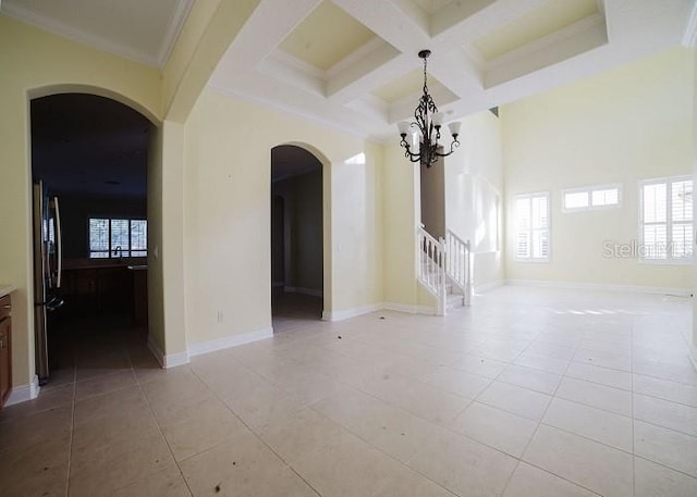 unfurnished room with coffered ceiling, light tile patterned floors, beam ceiling, and ornamental molding