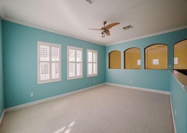 empty room with light carpet, crown molding, and ceiling fan