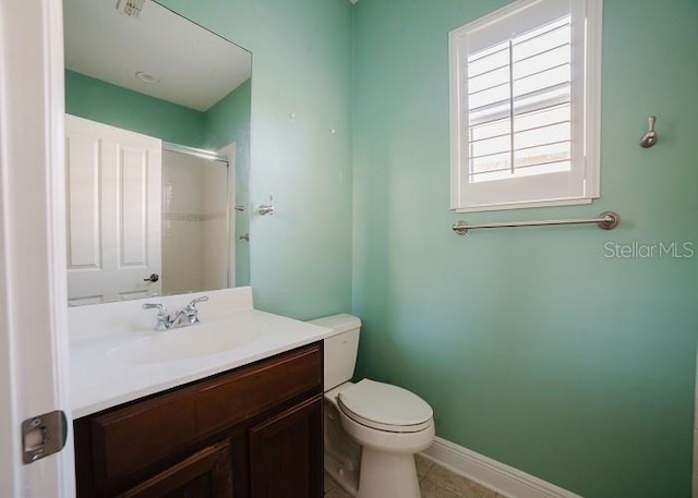 bathroom featuring tile patterned flooring, vanity, toilet, and a shower with shower door