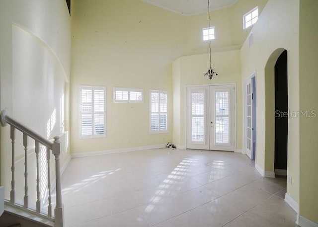 8162 Via Bella Notte, Orlando, FL 32836 - foyer entrance with a high ceiling, french doors, arched walkways, tile patterned flooring, and stairs