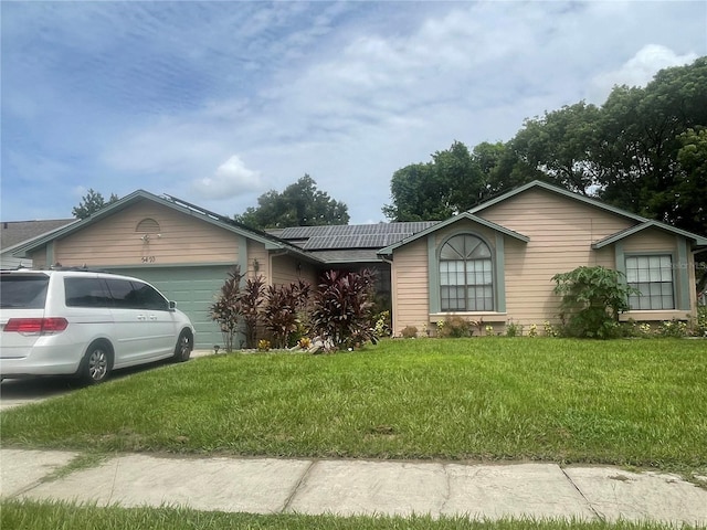 single story home featuring a garage and a front lawn