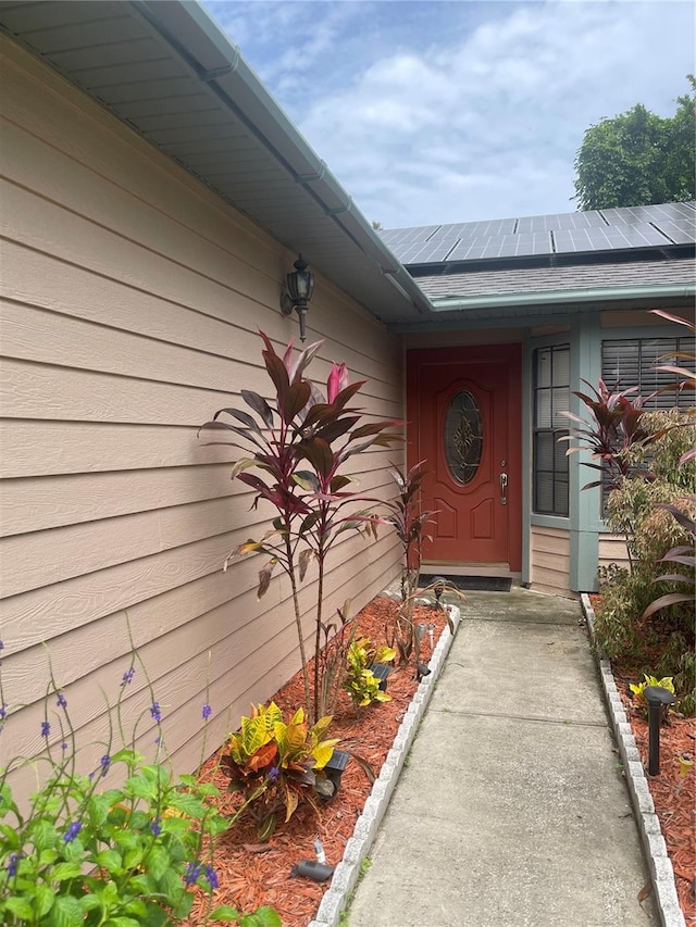 view of exterior entry featuring solar panels