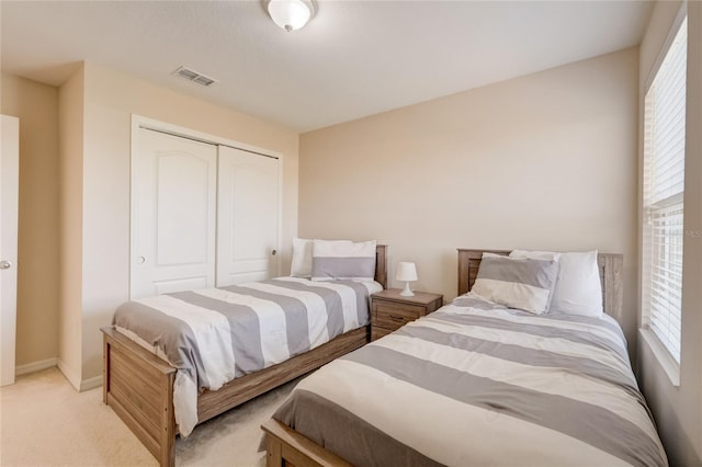 bedroom featuring light carpet, multiple windows, and a closet