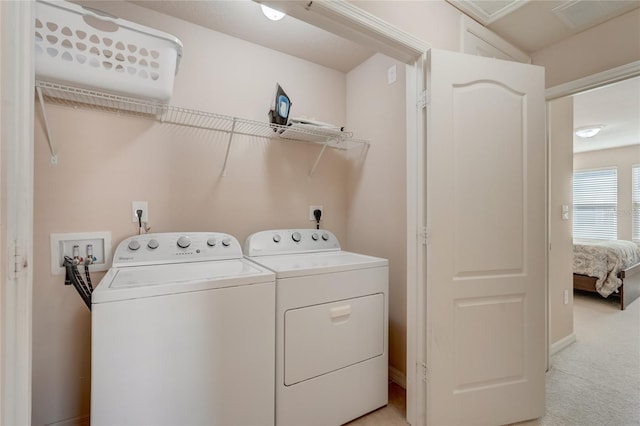 laundry room featuring washing machine and clothes dryer and light carpet