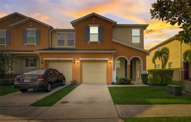 view of front of property with a yard, a garage, and central AC unit