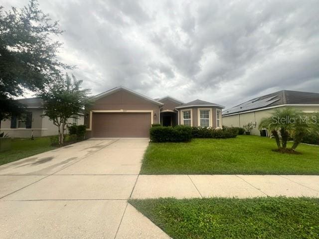 single story home featuring a garage and a front lawn