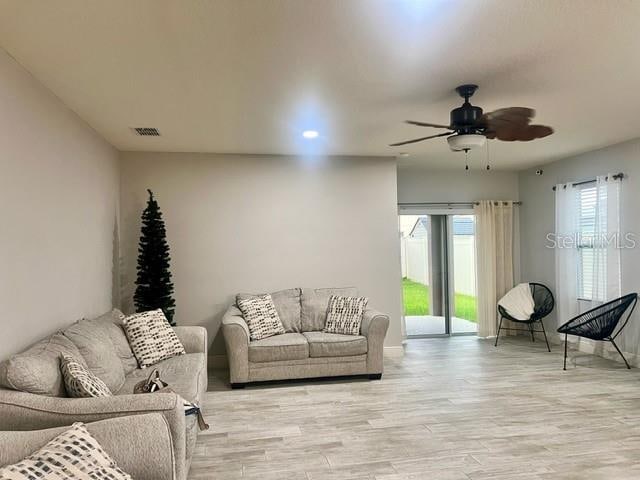 living room with ceiling fan and light hardwood / wood-style floors